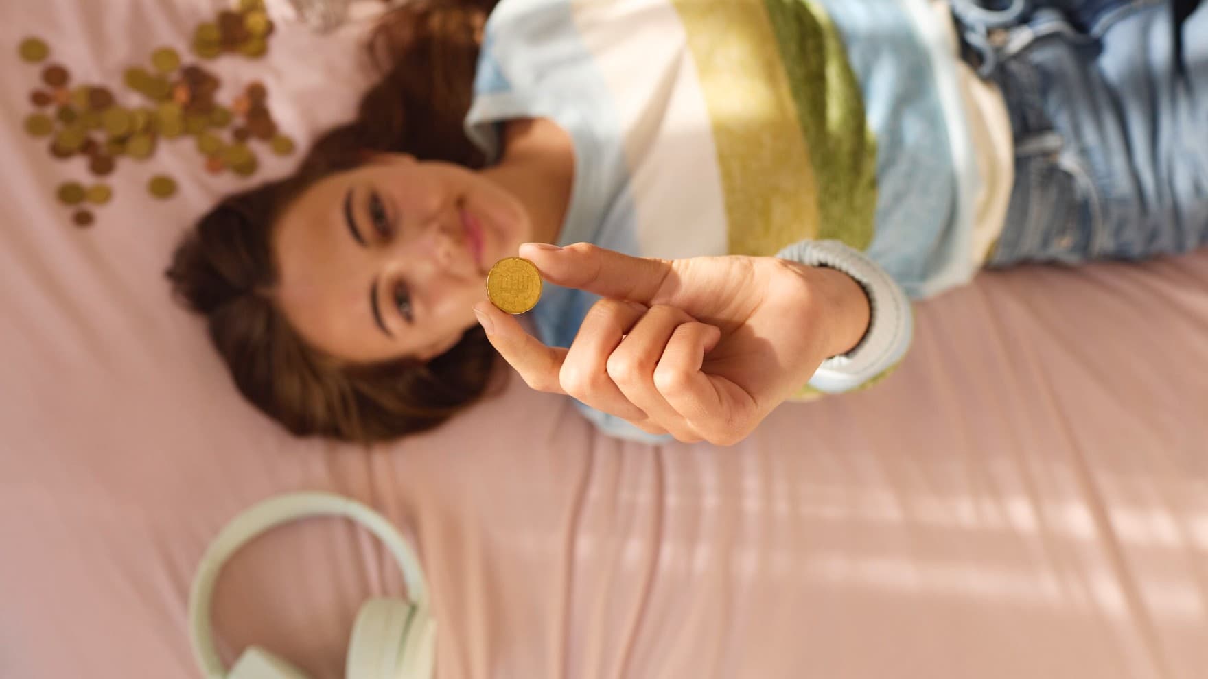 moteris guli ant sofos ir laiko rankoje centą