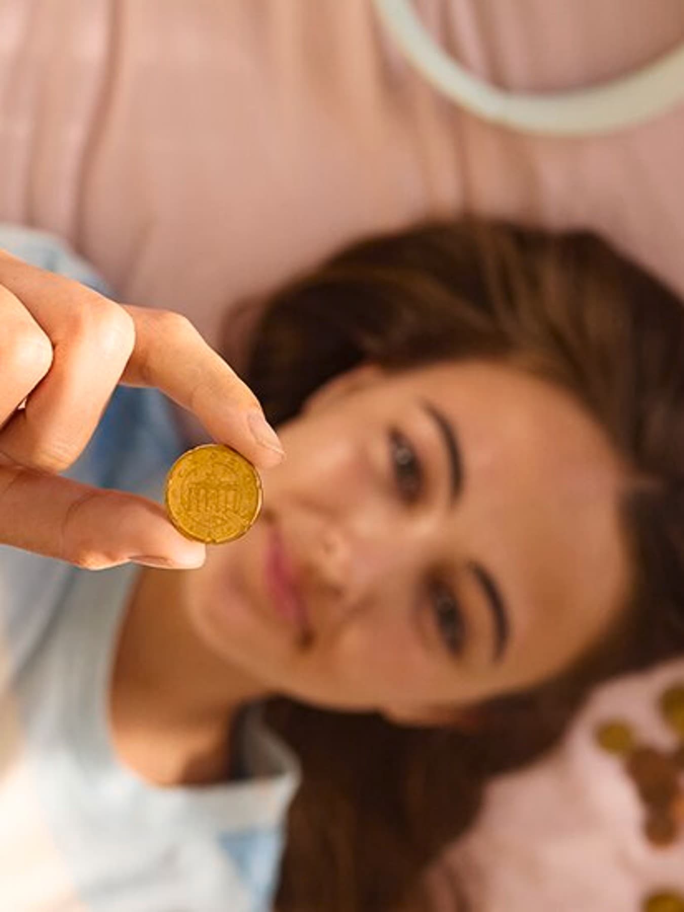 Moteris guli ant sofos ir laiko centą iškeltą į viršų